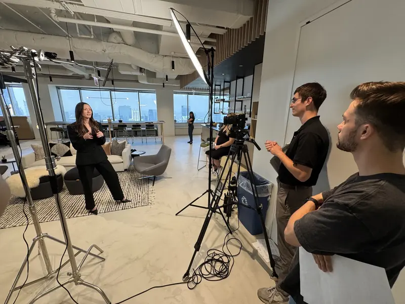 Small production team working around a seated interview under a large soft light