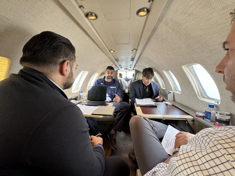 Crew members reviewing notes and equipment inside a small aircraft
